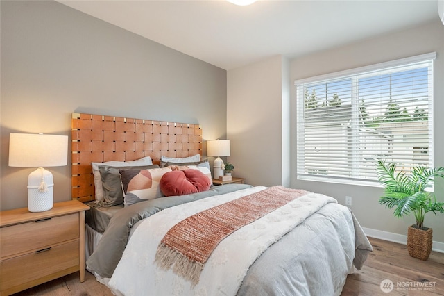 bedroom with vaulted ceiling and light wood-type flooring