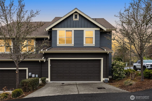 view of front of home featuring board and batten siding, concrete driveway, an attached garage, and a shingled roof