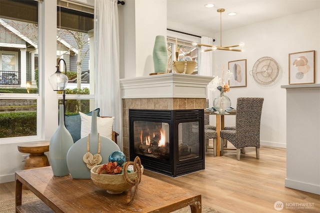 living area featuring recessed lighting, wood finished floors, baseboards, and a tile fireplace