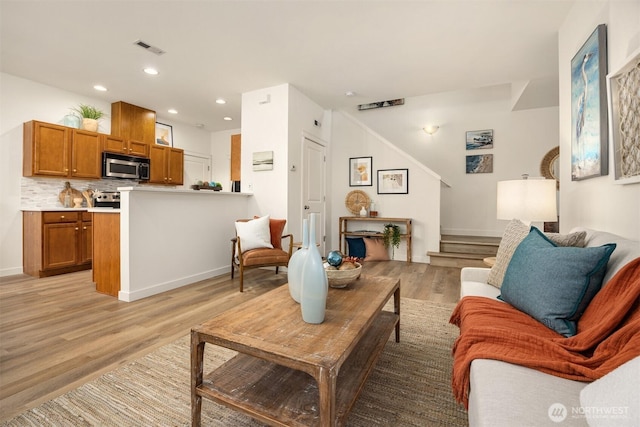 living area featuring stairway, recessed lighting, visible vents, and light wood-type flooring