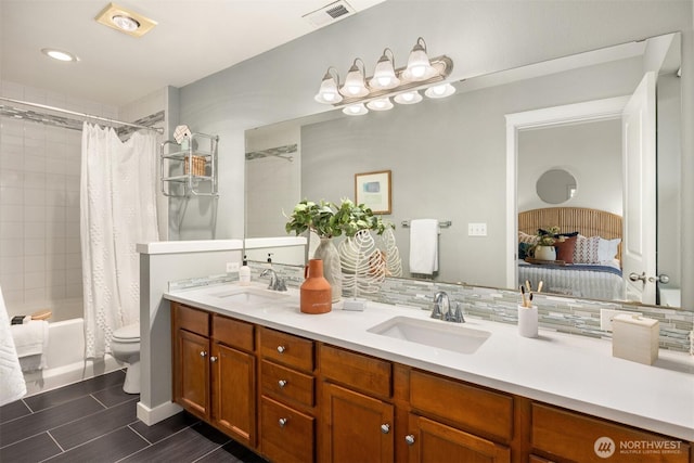 ensuite bathroom with double vanity, visible vents, connected bathroom, and a sink