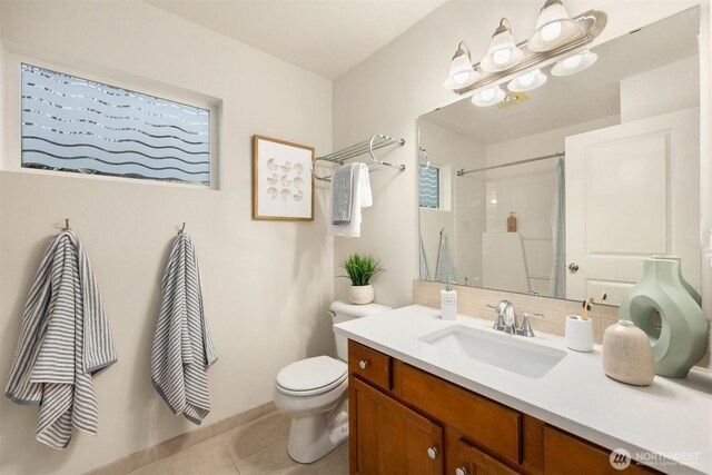 full bath with tile patterned flooring, backsplash, toilet, vanity, and a shower