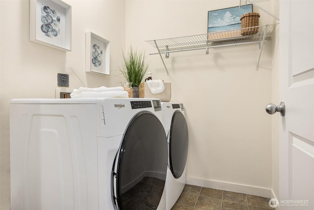 washroom with washer and clothes dryer, laundry area, dark tile patterned floors, and baseboards