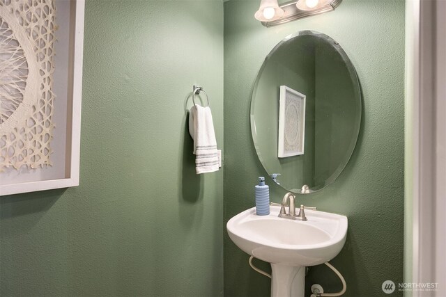 bathroom featuring a sink and a textured wall