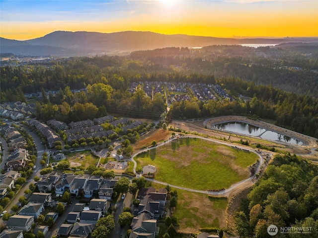 birds eye view of property with a forest view and a water and mountain view