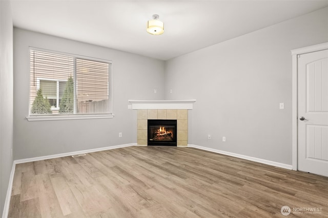 unfurnished living room featuring a fireplace and wood-type flooring