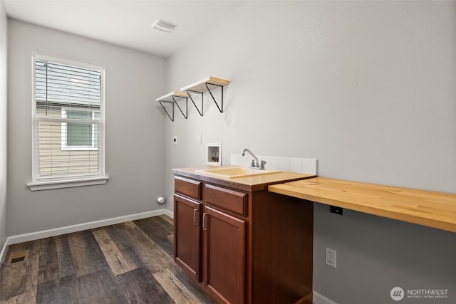 laundry room with dark wood-type flooring, washer hookup, hookup for an electric dryer, sink, and cabinets