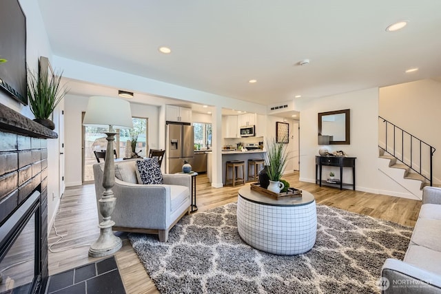 living room featuring light hardwood / wood-style flooring and a tile fireplace