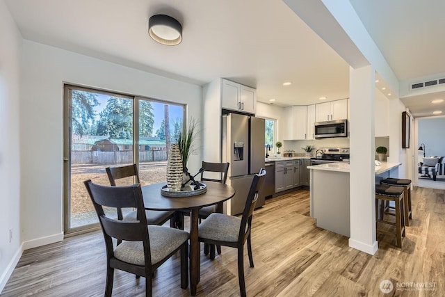 dining area with sink and light hardwood / wood-style flooring