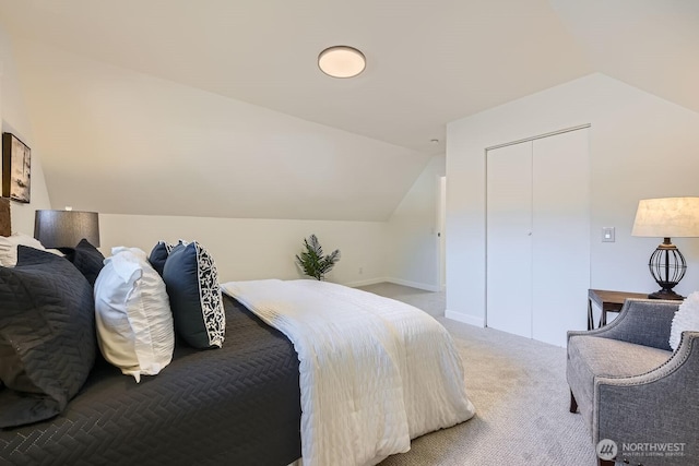 bedroom with a closet, vaulted ceiling, and light carpet