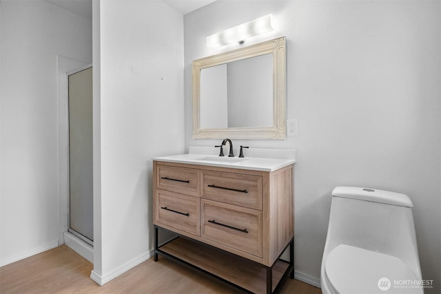 bathroom featuring vanity, toilet, an enclosed shower, and hardwood / wood-style floors