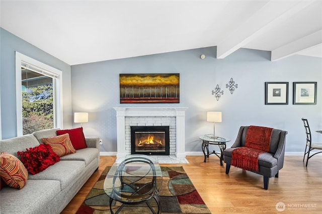 living room featuring wood-type flooring, a brick fireplace, and vaulted ceiling with beams