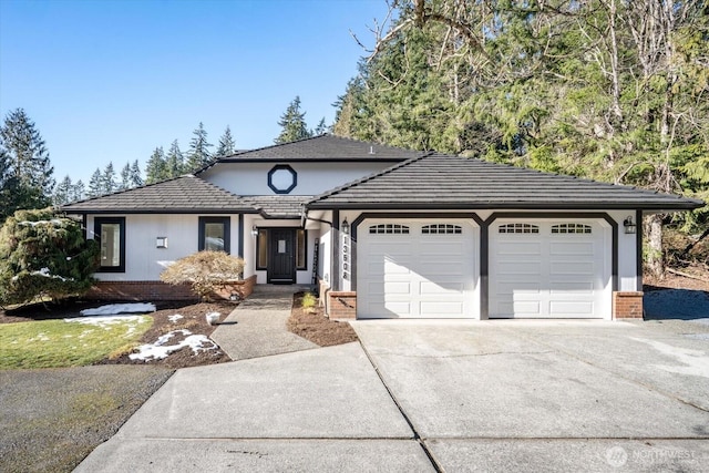 view of front of property with a garage, concrete driveway, and brick siding