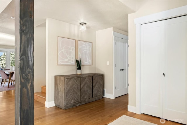 corridor with baseboards and wood finished floors