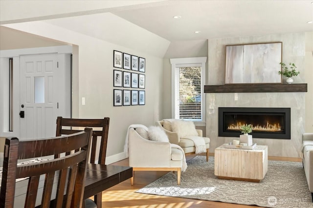 sitting room with wood finished floors, a glass covered fireplace, and baseboards