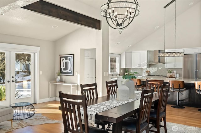 dining room with french doors, plenty of natural light, light wood-style flooring, and beamed ceiling