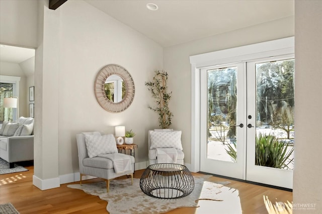 sitting room with lofted ceiling, french doors, wood finished floors, and a wealth of natural light