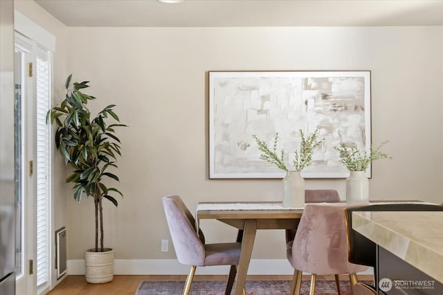 dining space with wood finished floors and baseboards