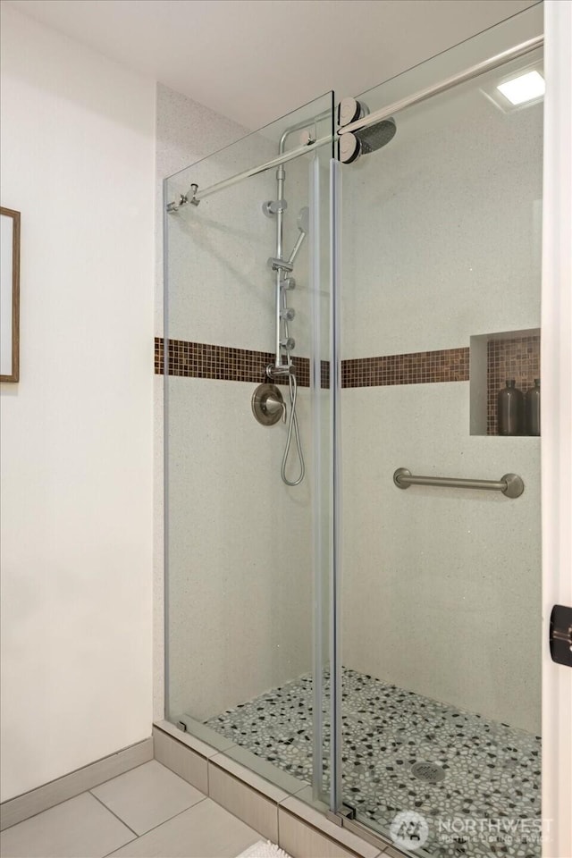 bathroom featuring tile patterned flooring and a shower stall