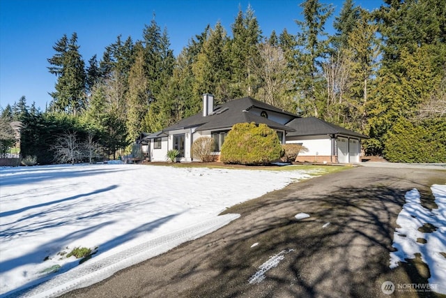 view of front of property with a chimney and an attached garage