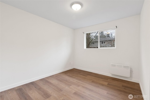 unfurnished room with light wood-type flooring and baseboards