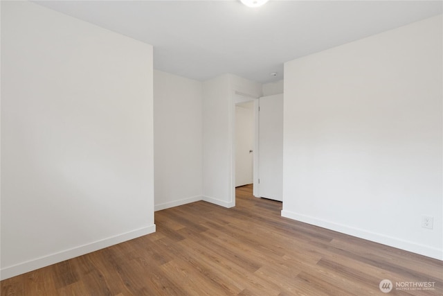 spare room with light wood finished floors and baseboards