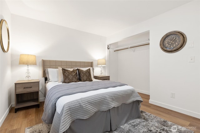 bedroom featuring a closet, baseboards, and wood finished floors