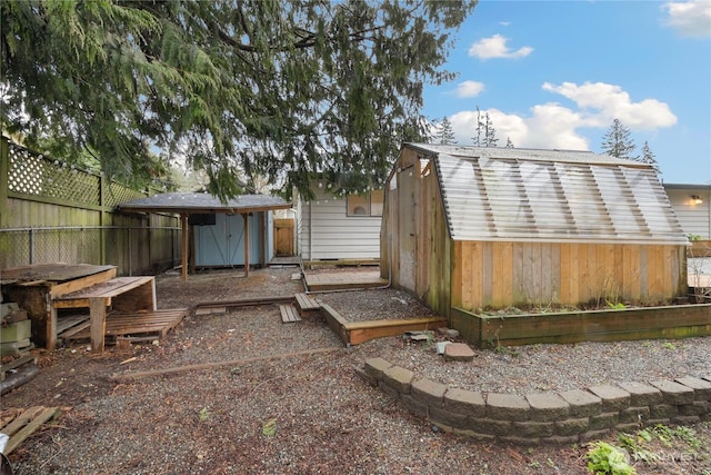 rear view of property with an outbuilding, a storage shed, and fence