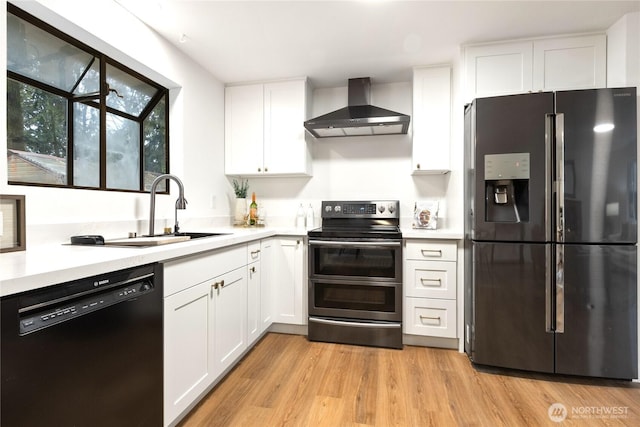 kitchen with appliances with stainless steel finishes, white cabinets, light countertops, and wall chimney exhaust hood