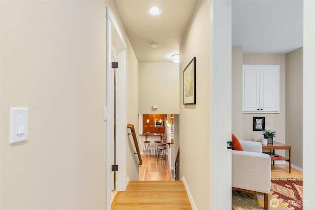 hall with recessed lighting, baseboards, light wood finished floors, and an upstairs landing