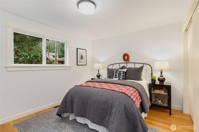 bedroom with visible vents, baseboards, and wood finished floors