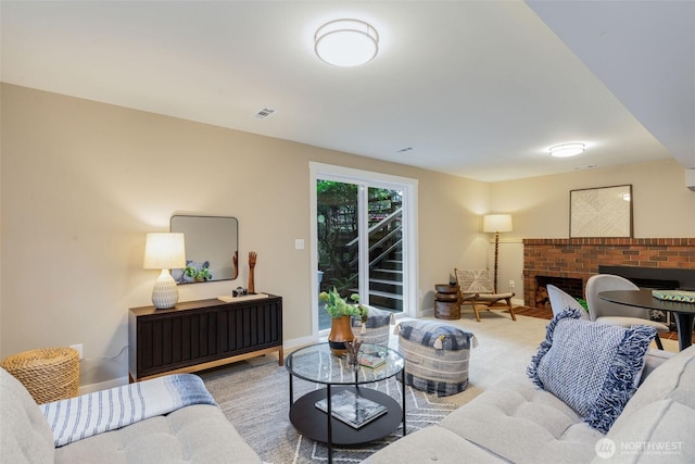 living area featuring a brick fireplace, visible vents, and baseboards