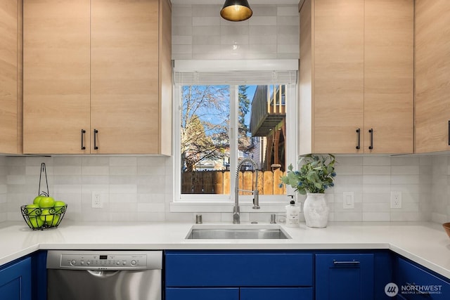 kitchen with stainless steel dishwasher, light brown cabinetry, sink, and decorative backsplash