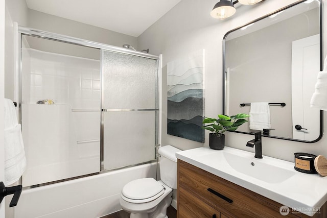 full bathroom with toilet, vanity, and bath / shower combo with glass door