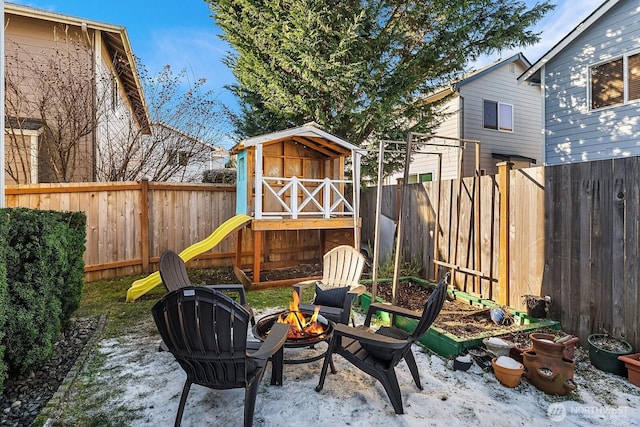 view of patio featuring a storage shed and a fire pit