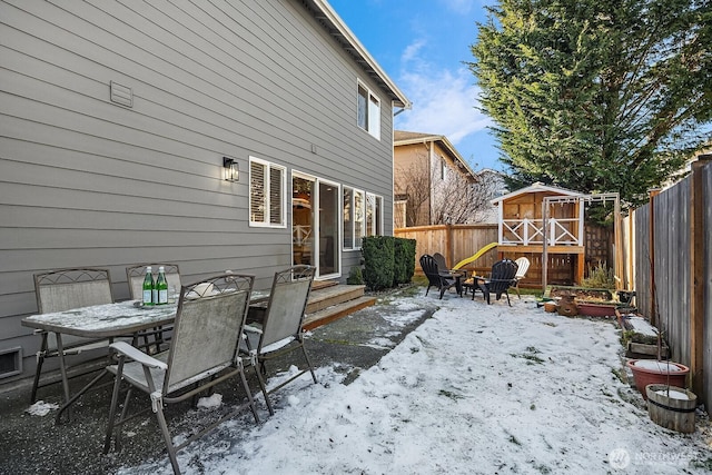 snow covered patio featuring an outdoor fire pit