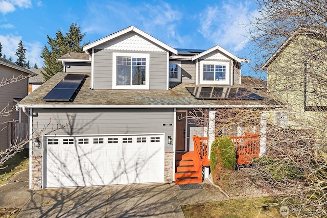 view of front facade featuring a garage and solar panels