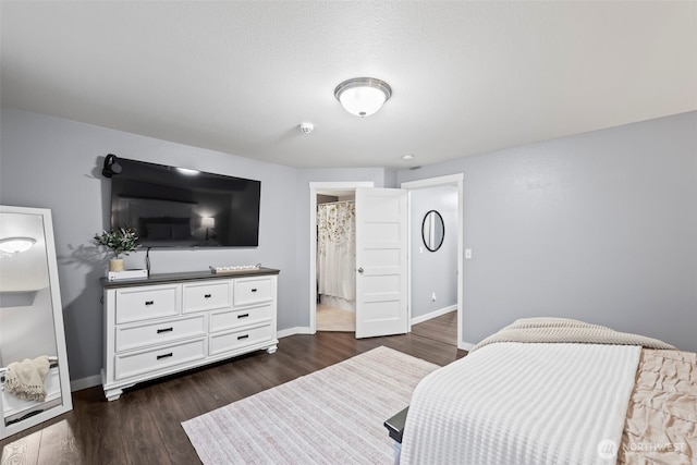 bedroom featuring baseboards and dark wood-type flooring