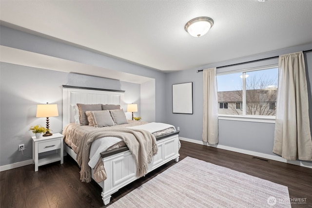 bedroom with dark wood-style flooring, baseboards, and visible vents