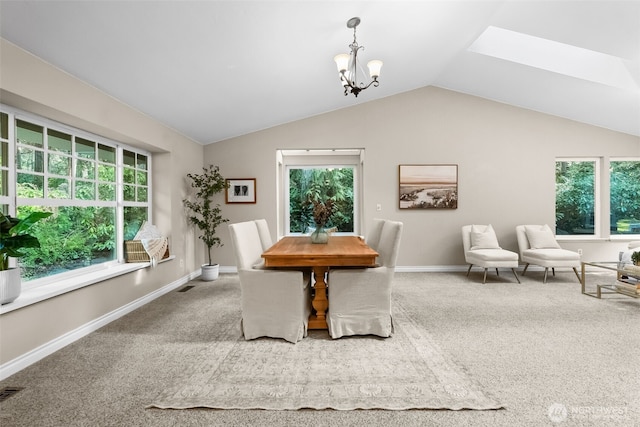 carpeted dining space with vaulted ceiling with skylight and a notable chandelier