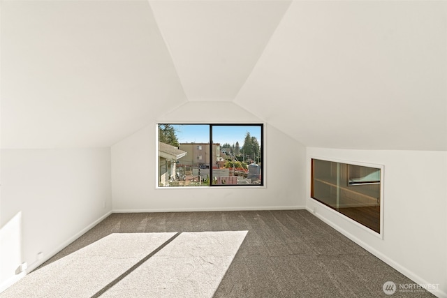 bonus room featuring dark colored carpet and vaulted ceiling