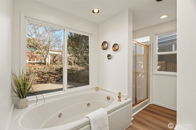 bathroom with wood-type flooring and shower with separate bathtub