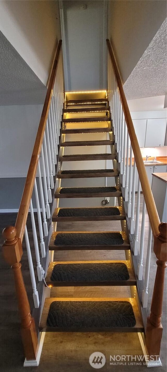 stairs with a textured ceiling