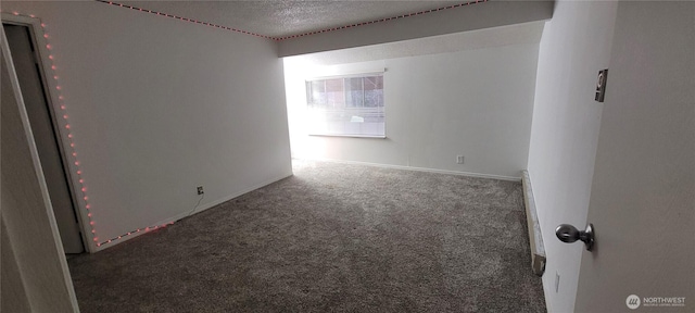 carpeted empty room with a textured ceiling and baseboards