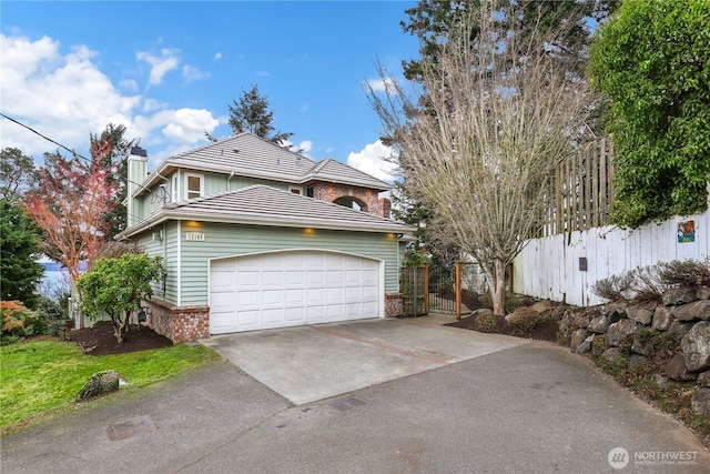 view of front of property with an attached garage, brick siding, fence, a tile roof, and concrete driveway