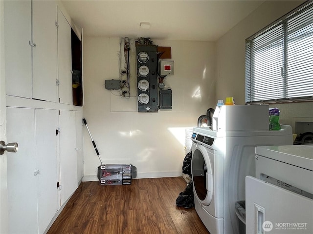 laundry room featuring cabinets, dark wood-type flooring, electric panel, and independent washer and dryer