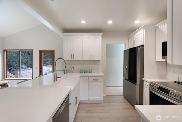 kitchen featuring sink, white cabinets, stainless steel appliances, and light hardwood / wood-style flooring