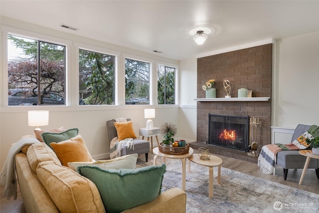 interior space featuring hardwood / wood-style flooring, a brick fireplace, and a wealth of natural light