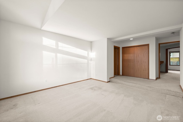 unfurnished bedroom featuring light colored carpet and a closet