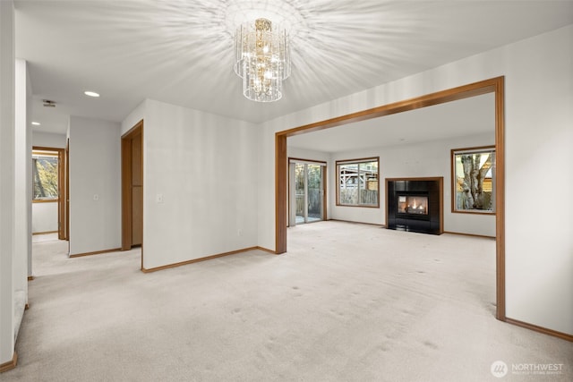 empty room featuring light carpet, a notable chandelier, and a multi sided fireplace